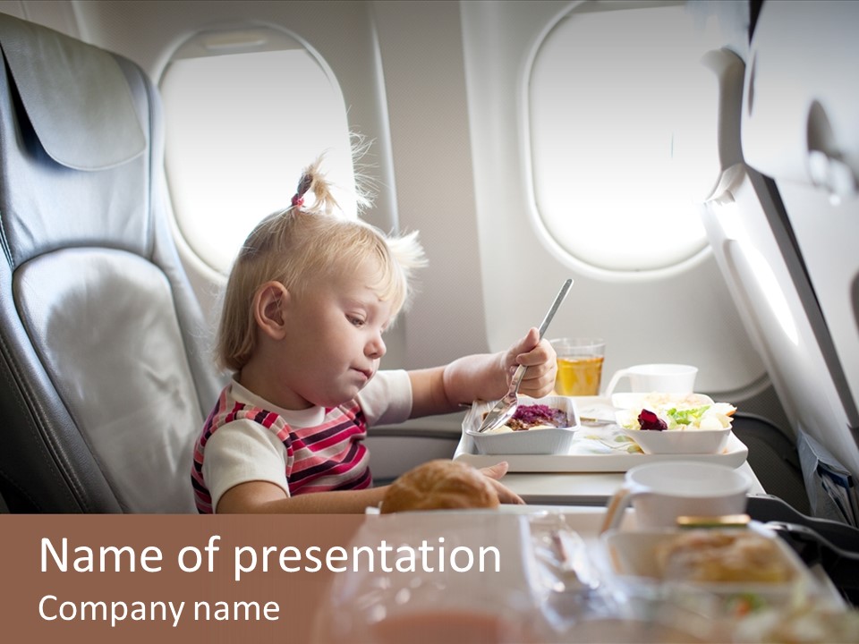 A Little Girl Sitting In An Airplane Eating A Meal PowerPoint Template