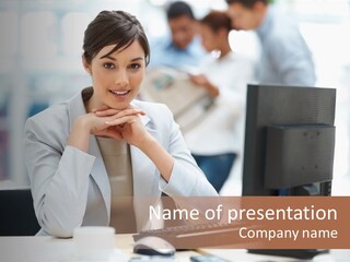 A Woman Sitting At A Desk In Front Of A Computer PowerPoint Template