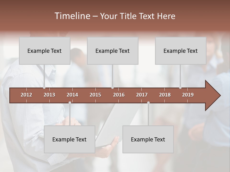 A Man Holding A Laptop In Front Of A Group Of People PowerPoint Template