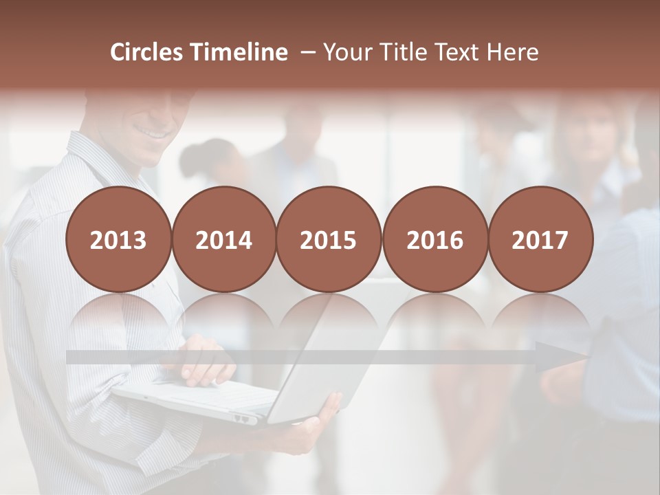 A Man Holding A Laptop In Front Of A Group Of People PowerPoint Template