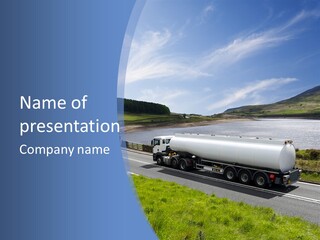 A Tanker Truck Driving Down A Road Next To A Lake PowerPoint Template