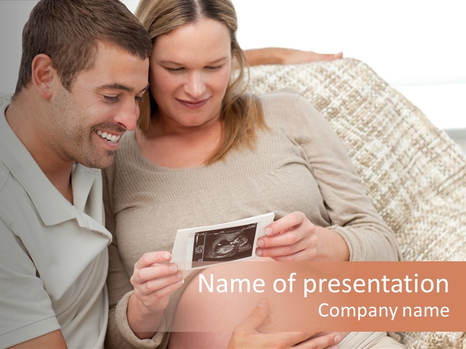 A Man And Woman Sitting On A Couch Looking At A Picture PowerPoint Template