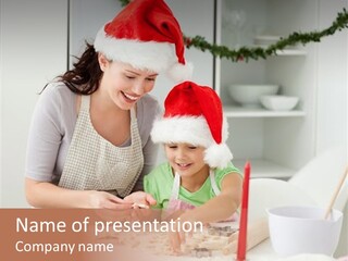 A Woman And A Child In Santa Hats Are At A Table PowerPoint Template