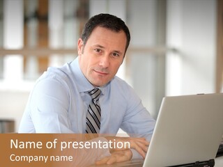 A Man Sitting In Front Of A Laptop Computer PowerPoint Template