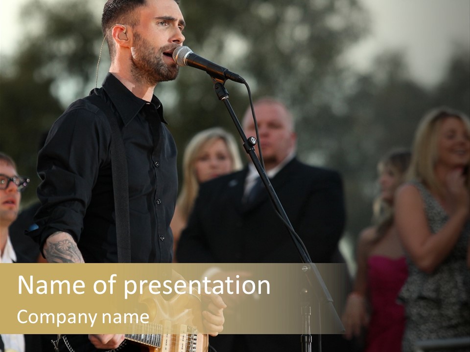 A Man Singing Into A Microphone While Holding A Guitar PowerPoint Template