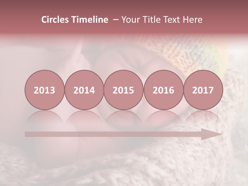 A Baby Wearing A Knitted Hat Laying On Top Of A Blanket PowerPoint Template