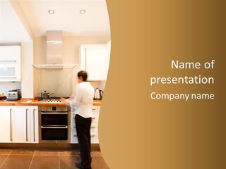 A Man Standing In A Kitchen Next To A Stove Top Oven PowerPoint Template
