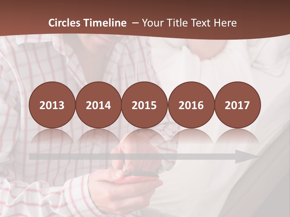 A Man Sitting On A Bed Looking At His Cell Phone PowerPoint Template