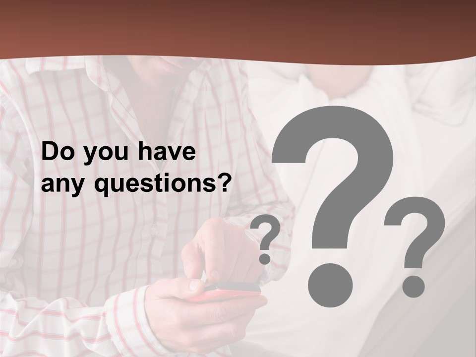 A Man Sitting On A Bed Looking At His Cell Phone PowerPoint Template