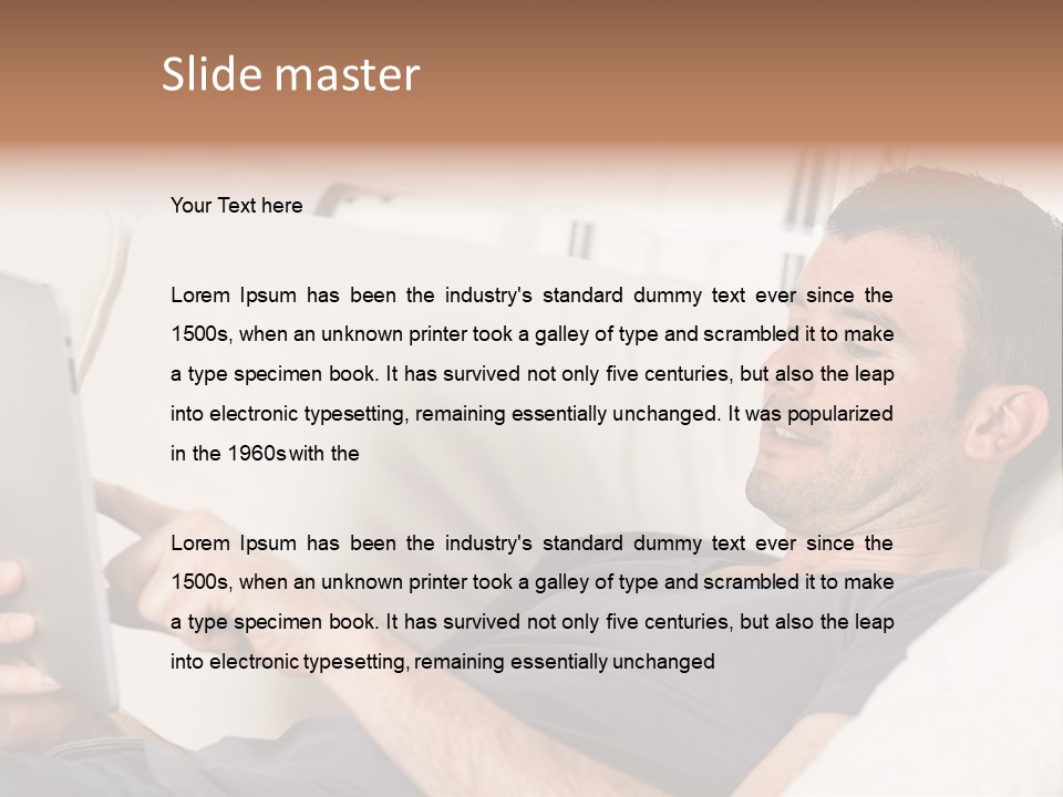 A Man Sitting On A Couch Looking At A Tablet PowerPoint Template