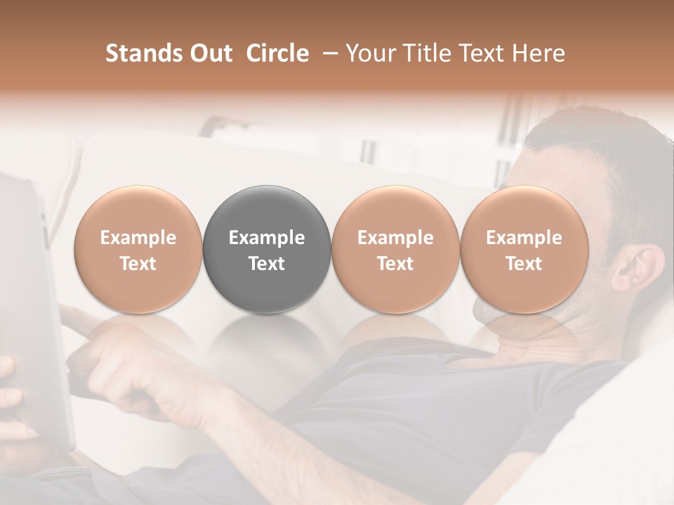 A Man Sitting On A Couch Looking At A Tablet PowerPoint Template