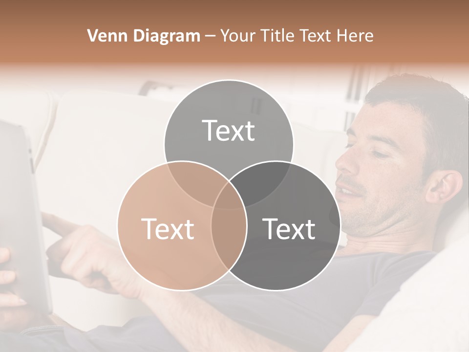 A Man Sitting On A Couch Looking At A Tablet PowerPoint Template