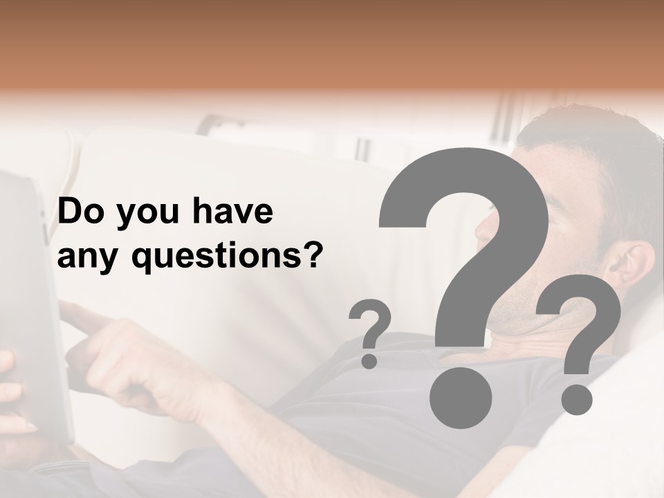 A Man Sitting On A Couch Looking At A Tablet PowerPoint Template