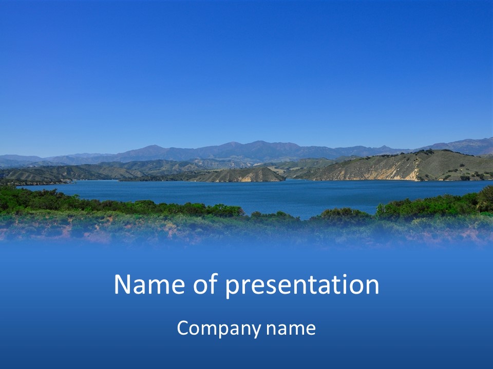 A Blue Lake With Mountains In The Background PowerPoint Template