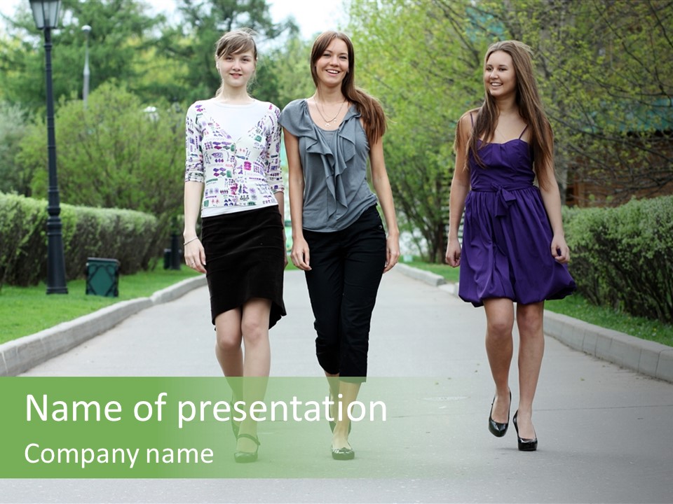 Three Girls Walking Down A Sidewalk In A Park PowerPoint Template