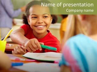 A Young Girl Smiles As She Sits At A Desk PowerPoint Template