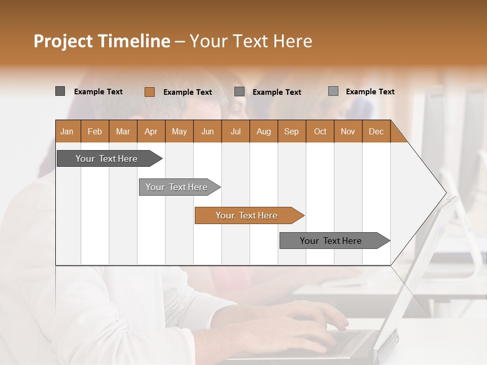 A Group Of People Sitting At A Table With Computers PowerPoint Template