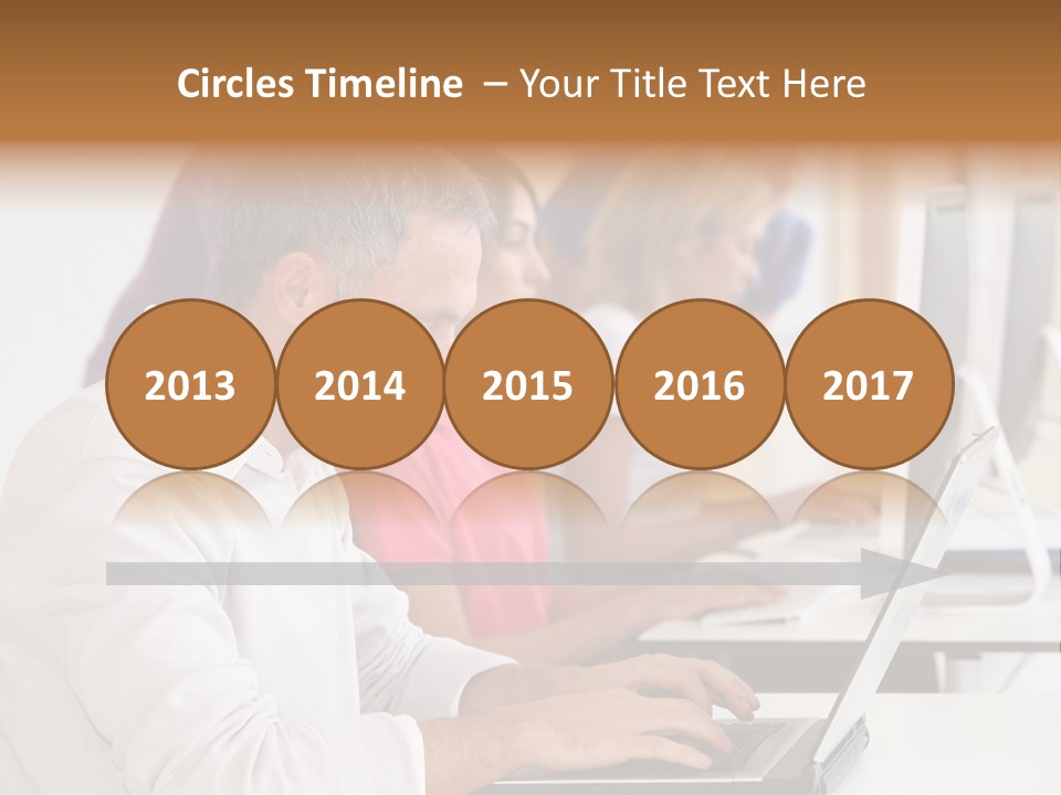 A Group Of People Sitting At A Table With Computers PowerPoint Template