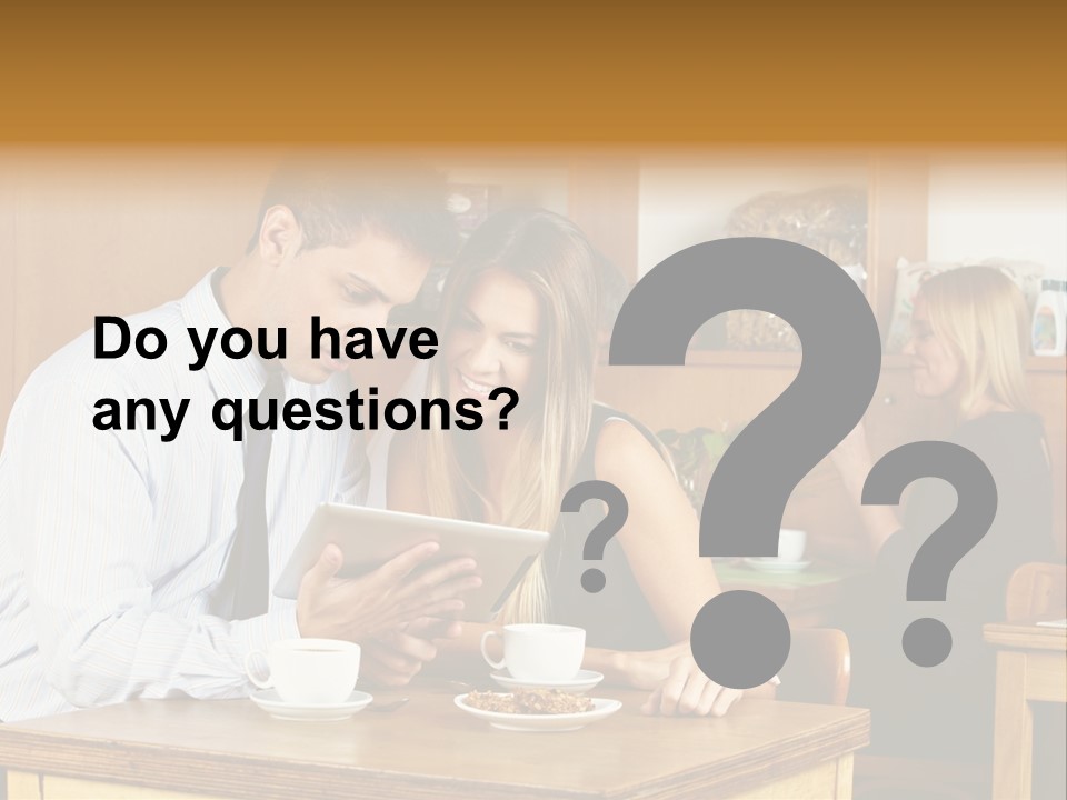 A Man And Woman Sitting At A Table Looking At A Tablet PowerPoint Template