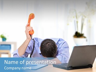 A Man Sitting At A Desk With A Laptop And Telephone PowerPoint Template