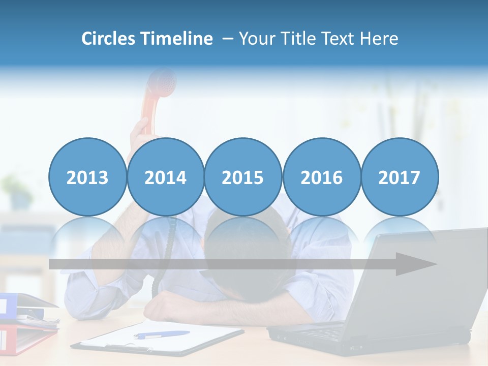 A Man Sitting At A Desk With A Laptop And Telephone PowerPoint Template