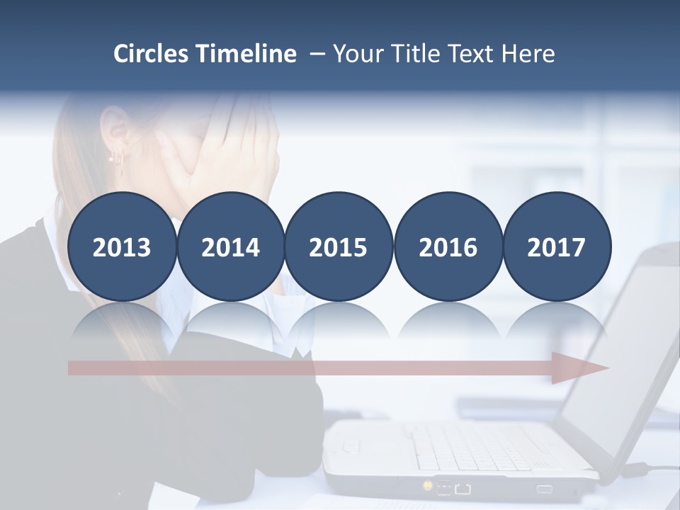 A Woman Sitting At A Desk Covering Her Face With Her Hands PowerPoint Template