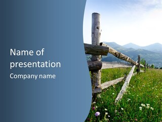 A Wooden Fence In A Grassy Field With Mountains In The Background PowerPoint Template