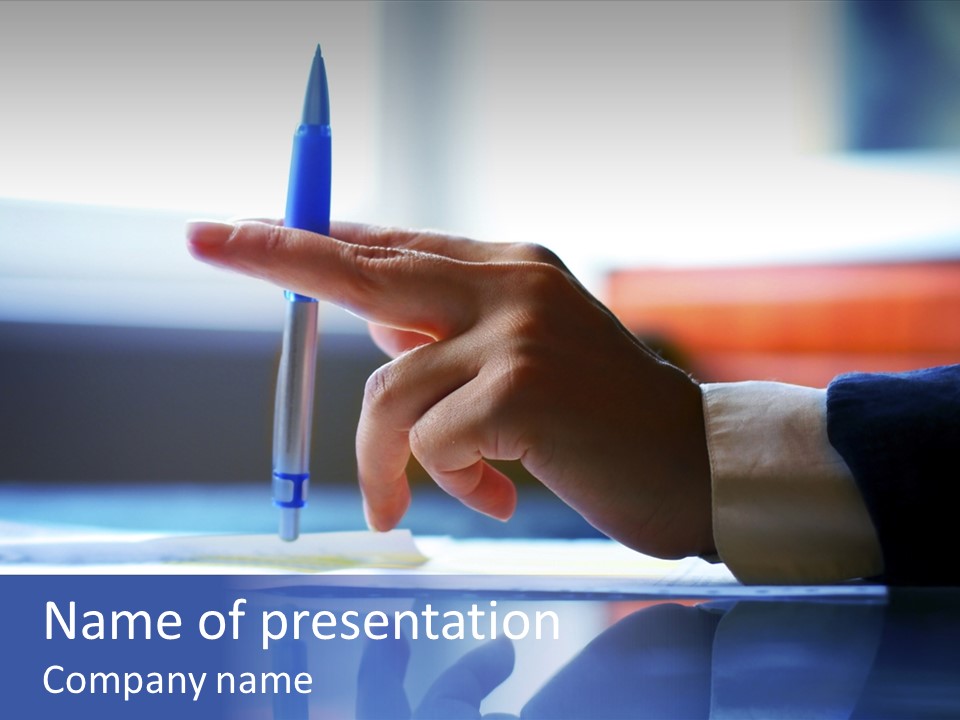 A Person Holding A Pen Over A Piece Of Paper PowerPoint Template