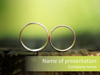 Two Wedding Rings Sitting On A Piece Of Wood PowerPoint Template