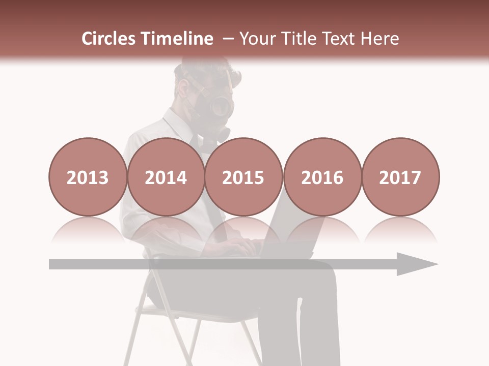 A Man Sitting On A Chair Using A Laptop Computer PowerPoint Template