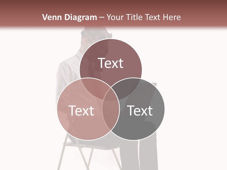 A Man Sitting On A Chair Using A Laptop Computer PowerPoint Template