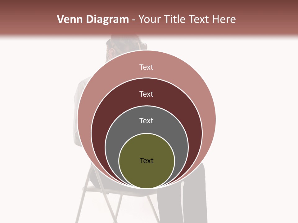 A Man Sitting On A Chair Using A Laptop Computer PowerPoint Template
