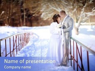 A Bride And Groom Standing On A Bridge In The Snow PowerPoint Template