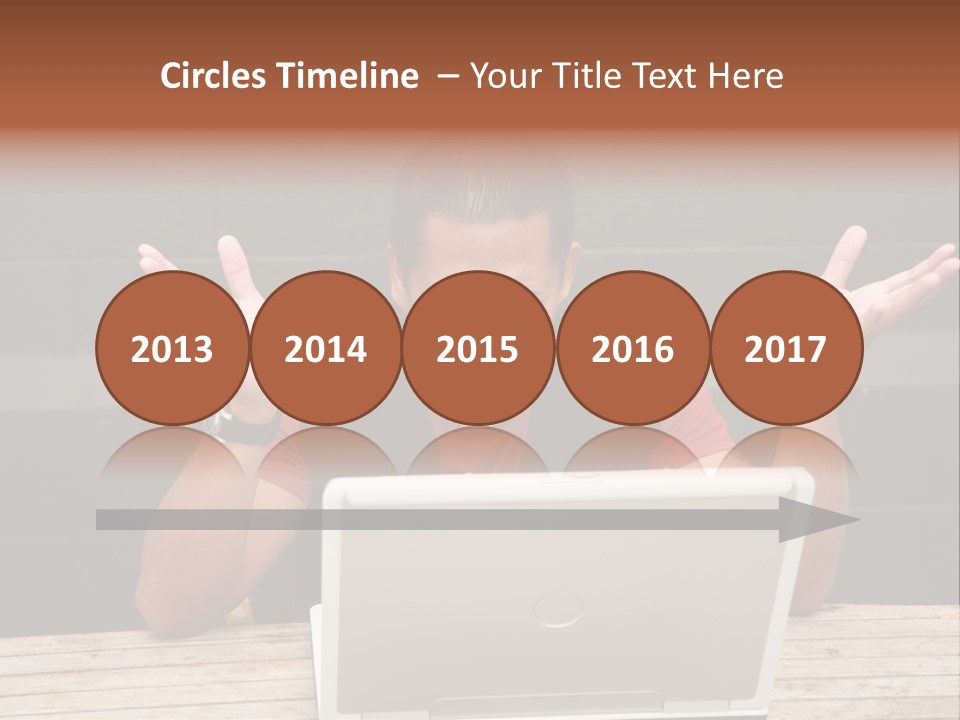 A Man Sitting In Front Of A Laptop Computer PowerPoint Template