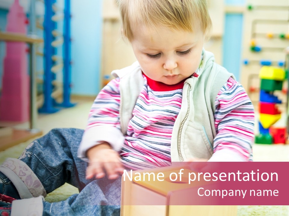 A Young Child Playing With A Toy Box PowerPoint Template