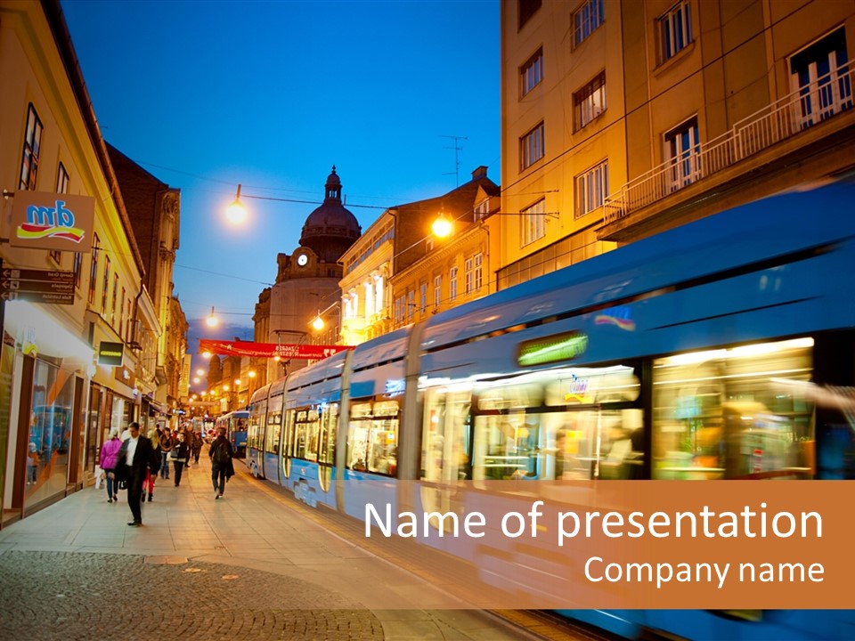 A Blue Train Traveling Down A Street Next To Tall Buildings PowerPoint Template