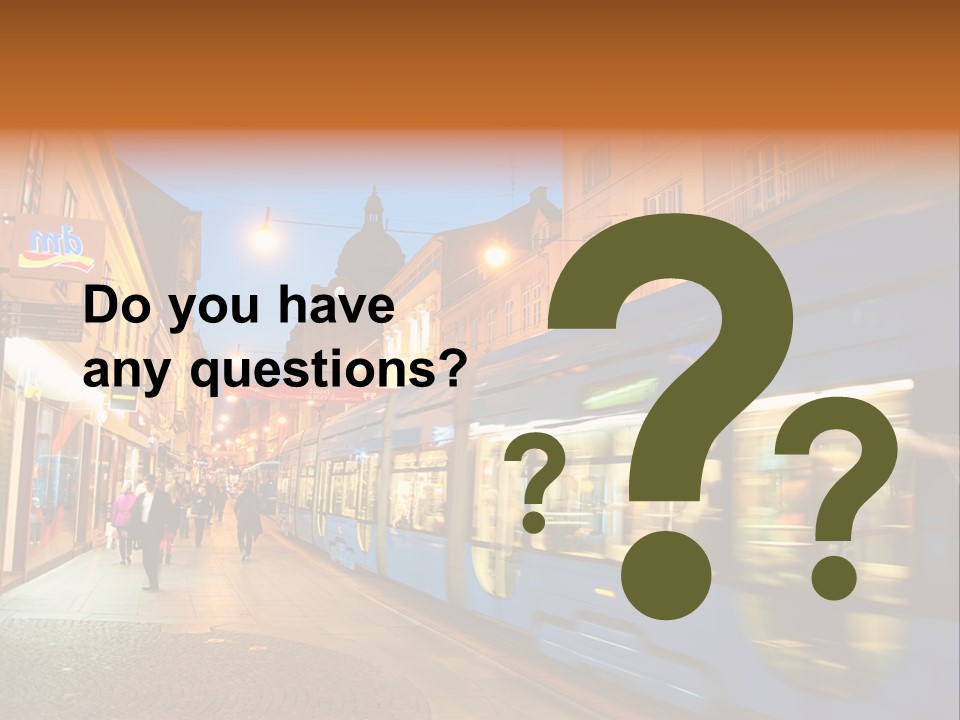 A Blue Train Traveling Down A Street Next To Tall Buildings PowerPoint Template