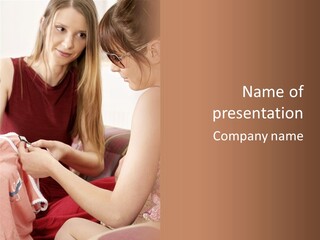 Two Women Sitting On A Couch Looking At A Piece Of Clothing PowerPoint Template