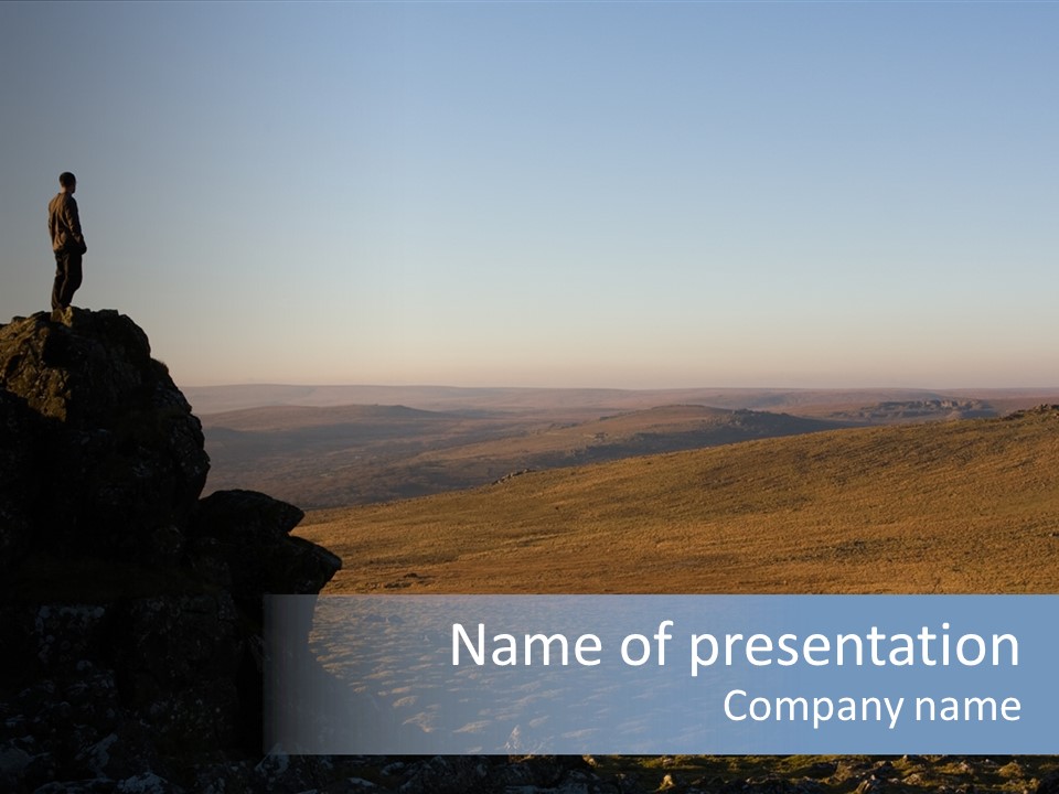 A Man Standing On Top Of A Large Rock PowerPoint Template