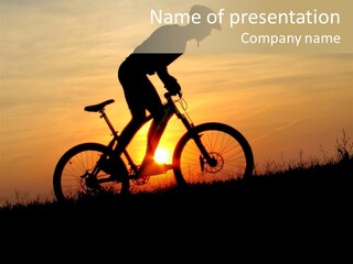 A Silhouette Of A Person Riding A Bike At Sunset PowerPoint Template