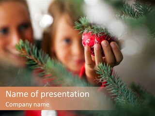 A Child Holding A Christmas Ornament In Front Of A Christmas Tree PowerPoint Template