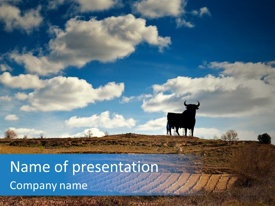 A Cow Standing On Top Of A Hill Under A Cloudy Blue Sky PowerPoint Template