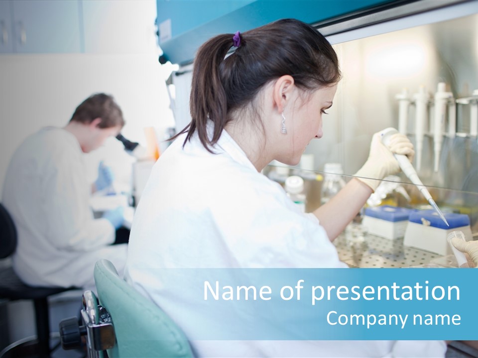 A Woman In White Lab Coat Working On A Machine PowerPoint Template