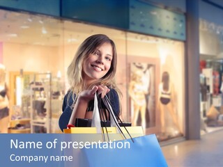 A Woman Holding Shopping Bags In Front Of A Store PowerPoint Template