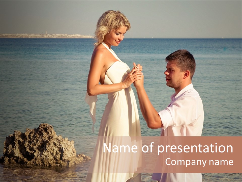 A Man And Woman Standing On A Beach Holding Hands PowerPoint Template