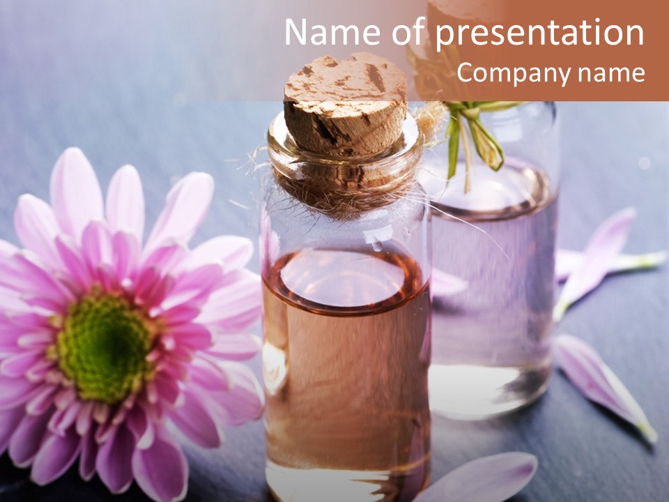 A Bottle Of Oil And A Flower On A Table PowerPoint Template