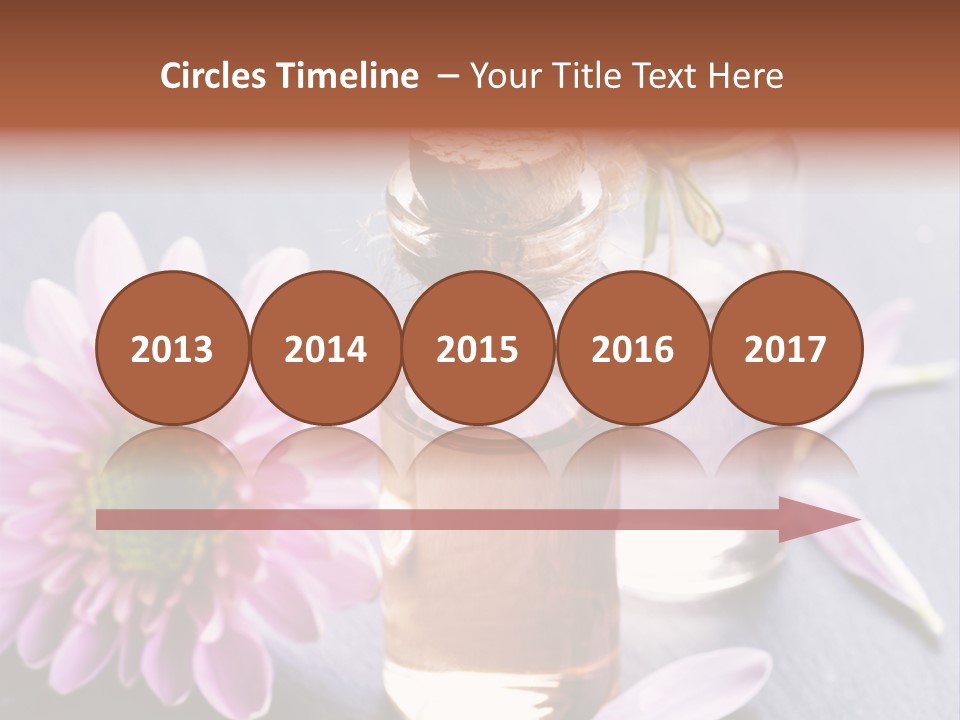 A Bottle Of Oil And A Flower On A Table PowerPoint Template