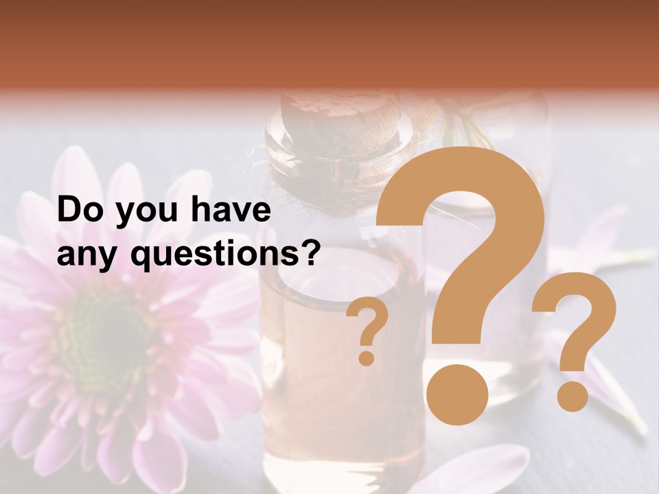 A Bottle Of Oil And A Flower On A Table PowerPoint Template