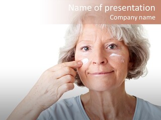 An Older Woman Holding A Cream On Her Face PowerPoint Template