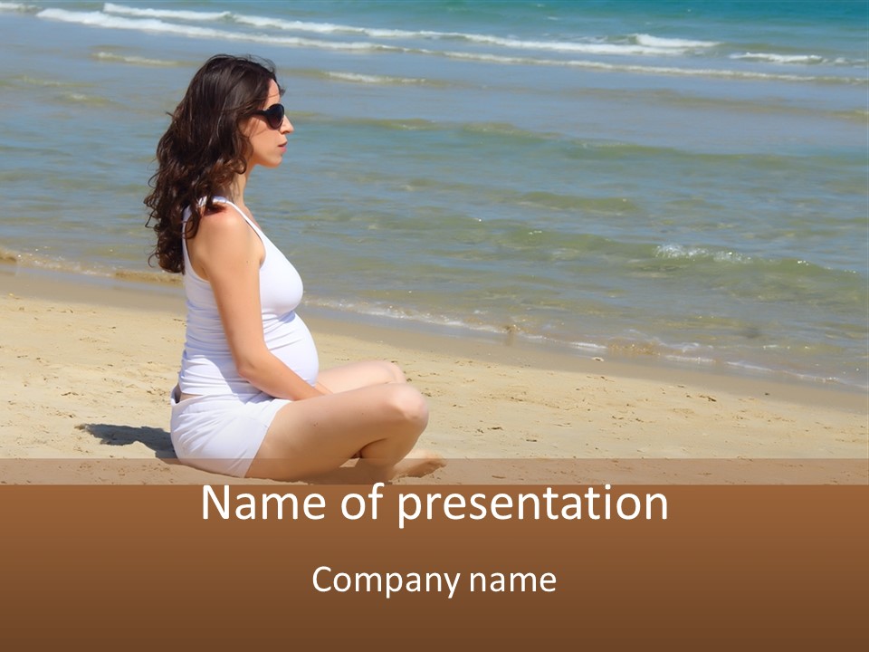 A Pregnant Woman Sitting On The Beach With The Ocean In The Background PowerPoint Template